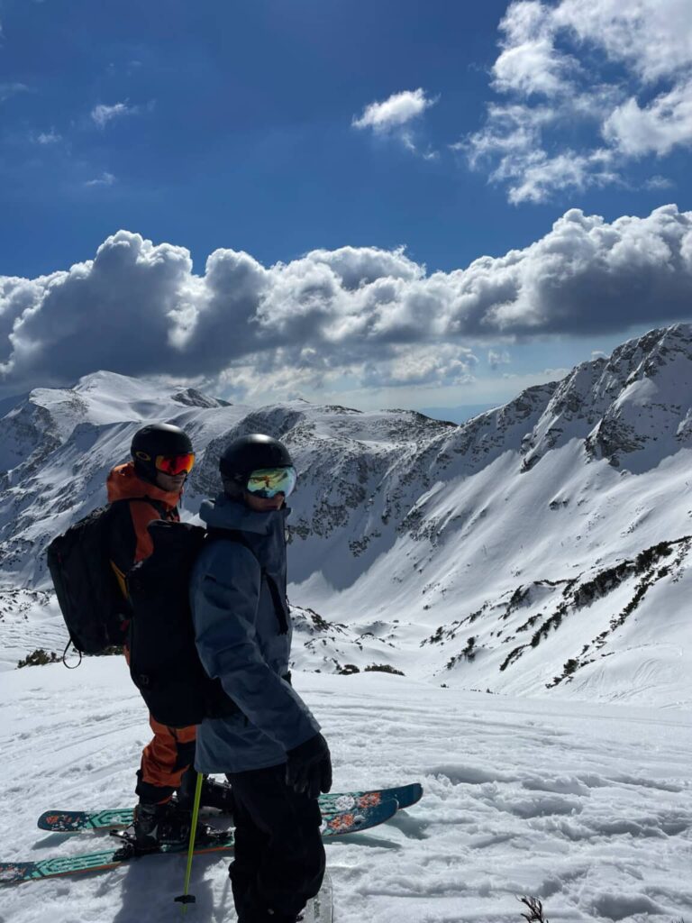 Two freeriders on skis looking out over the off-piste terrain