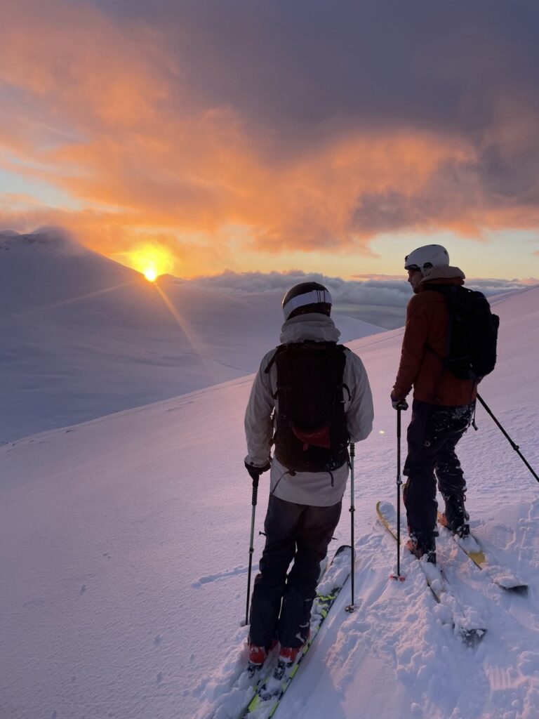 Skiers looking at the sunset