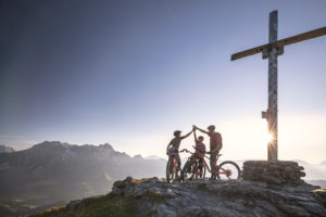 MTB åkare som gör highfive med solnedgången i bakgrunden