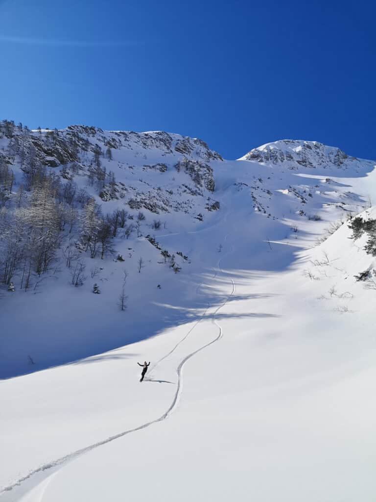 Freeriding person i offpisten masser af sne og flotte bjerge i baggrunden